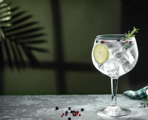 Gin Tonic Cocktail And Shadows Next To The Window On Dark Concrete Background.